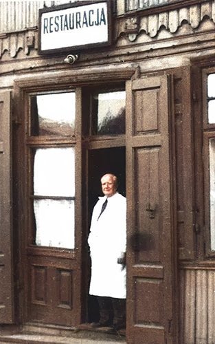 Antoni Jarząbek w drzwiach Baru Uniwersalnego, pod szyldem RESTAURACJA